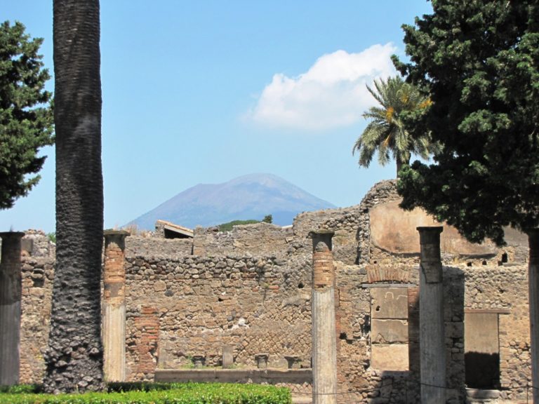 Pompeje byla vykopané z mocné vrstvy sopečného popela. V pozadí silueta sopky Vesuv.