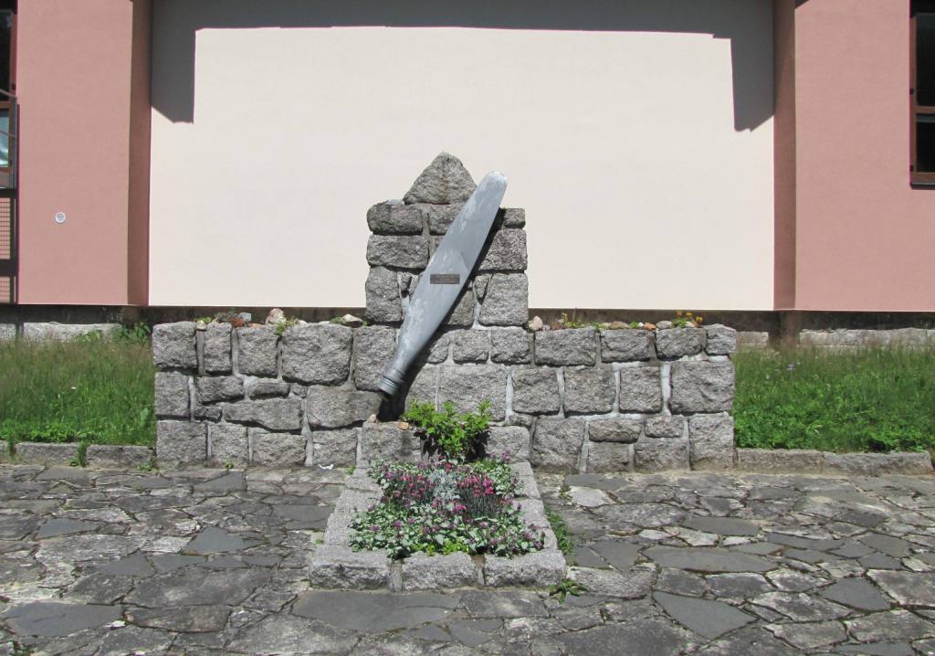 Památník v Harrachově je i místem, kde byly v roce 1948 pohřbeny ostatky pilota. 