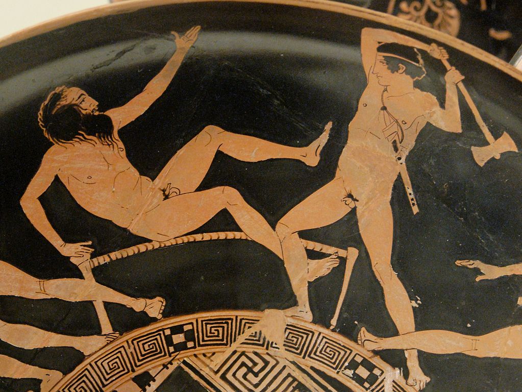 Prokrústés (vlevo), Théseus (vpravo). Právě mladý řecký hrdina Théseus učinil konec řádění krutého bandity. Použil proti němu jeho vlastní metodu. Na lůžku mu uťal sekerou přečnívající hlavu.  

Zdroj foto: British Museum, CC BY 2.5 , via Wikimedia Commons
