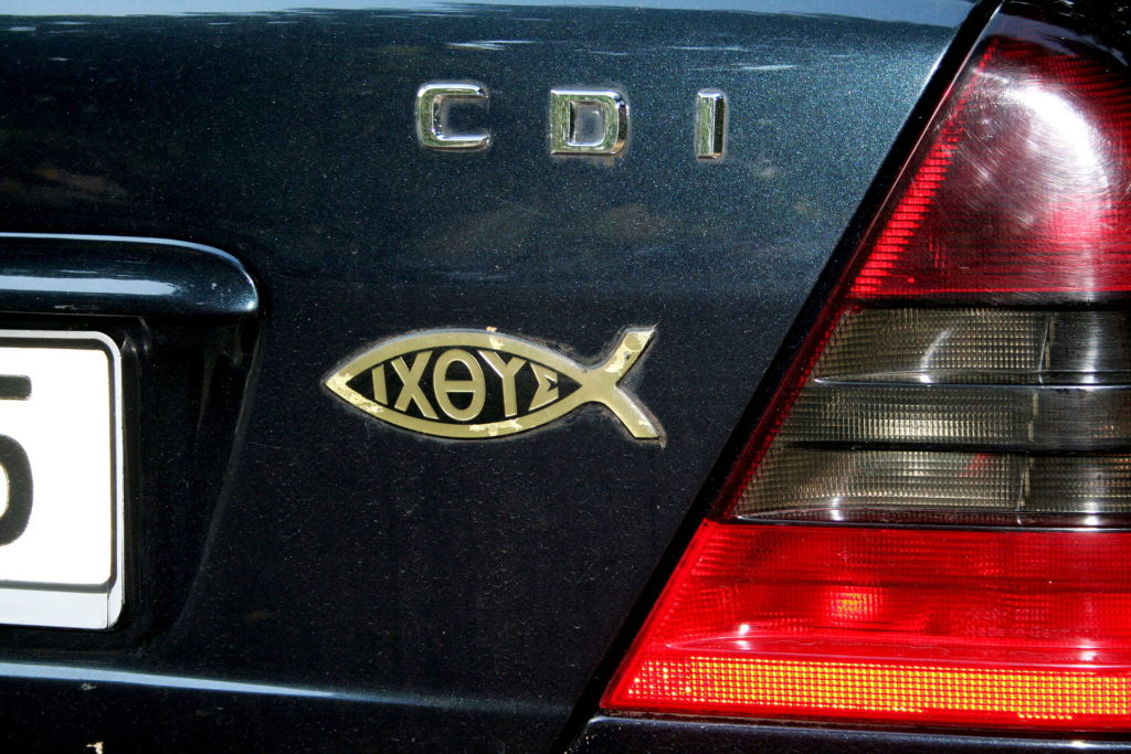 Symbol ryby na autě  můžete vidět i u nás, obvykle ale bez slova uvnitř.  ratatosk / Creative Commons - CC BY-SA 3.0 de