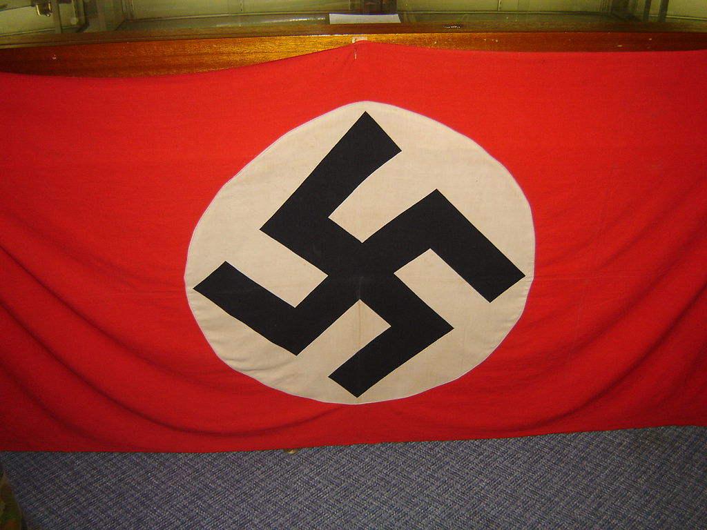 Hákový kříž na vlajce, kterou používala německá armáda při kampani v Severní Africe. Zdroj foto:  DO'Neil, CC BY-SA 3.0 , via Wikimedia Commons
 
