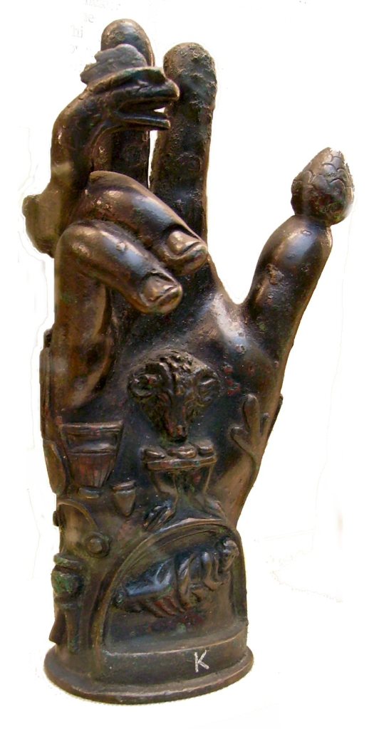 Na palci magické ruky je piniová šiška. Zdroj foto: Mike Young at English Wikipedia, Public domain, via Wikimedia Commons

