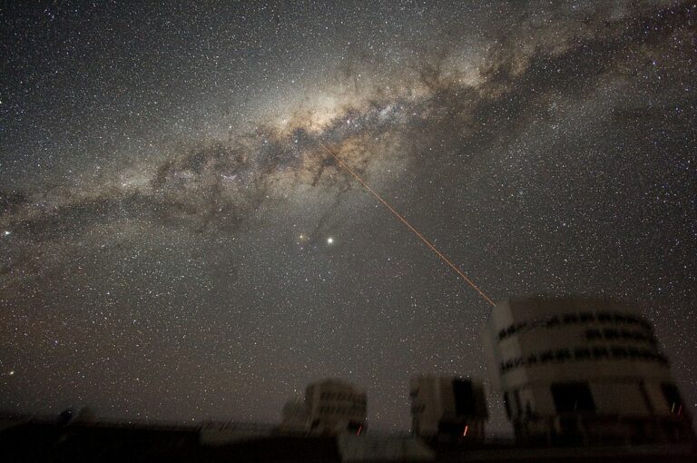 Při pohledu ze Země se Mléčná dráha jeví jako mlžný pás. Důvodem je fakt, že pozorujeme naši mateřskou galaxii jaksi zevnitř. Paprsek na snímku je laser usnadňující zaměření teleskopu. Zdroj foto: ESO/Y. Beletsky, CC BY 4.0 , via Wikimedia Commons