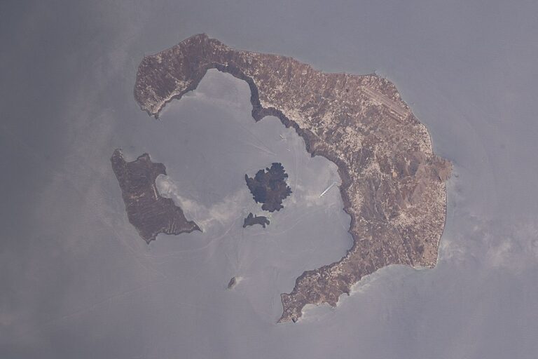 Pohled na kalderu ostrova Théra. Právě do těchto míst je často umisťována bájná Atlantida. Zdroj foto: NASA, Public domain, via Wikimedia Commons