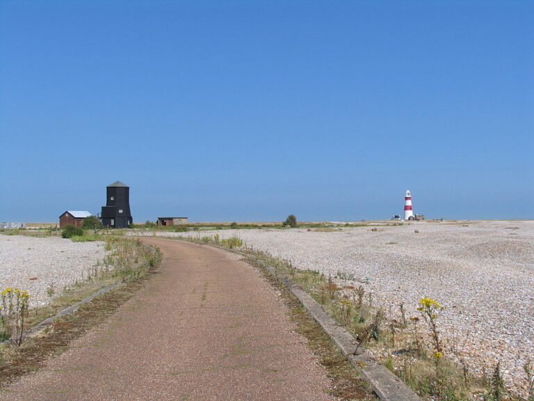 Cesta vedoucí k pobřeží Severního moře v oblasti Suffolku. V pravé části snímku historický maják. Zdroj foto: Simon James from Darlington, UK, CC BY-SA 2.0 , via Wikimedia Commons