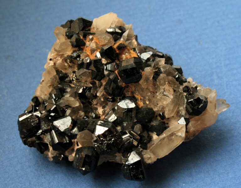 Kasiterit, česky cínovec. Na snímku je tento minerál doplněný i o krystaly křemene. Zdroj foto: Ralph Bottrill, CC BY 3.0 <https://creativecommons.org/licenses/by/3.0>, via Wikimedia Commons