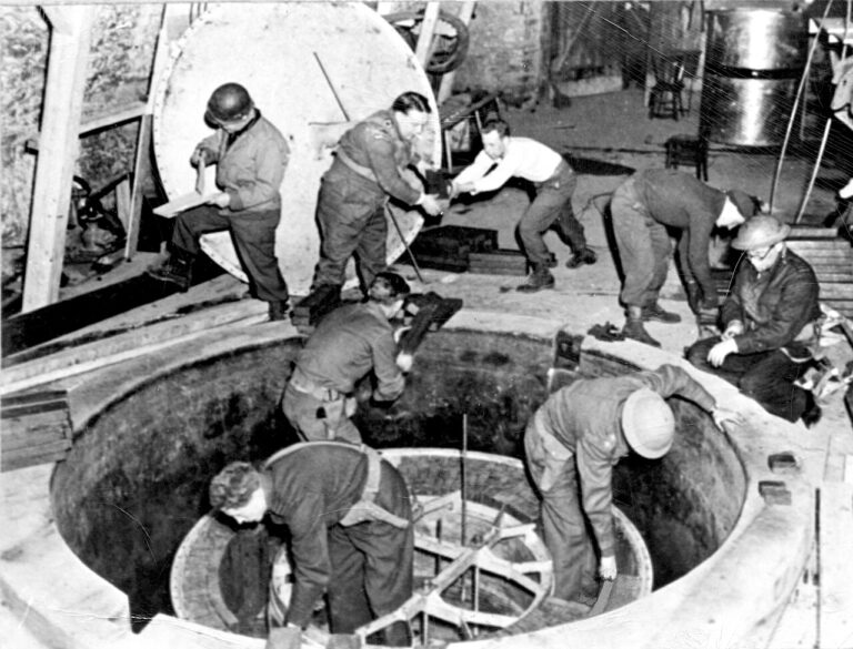 „Demontáž německého jaderného reaktoru v Haigerlochu, duben 1945. V popředí Rupert Cecil, vpravo profesor Frederick ‚Bimbo‘ Norman.